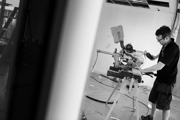 Black & white documentary style photo of man woodworking