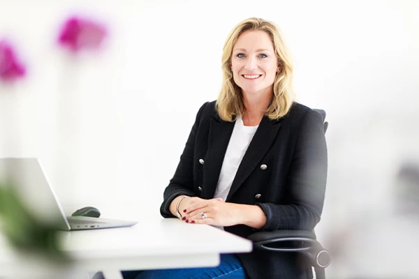 Colour photo of a woman sitting at a table