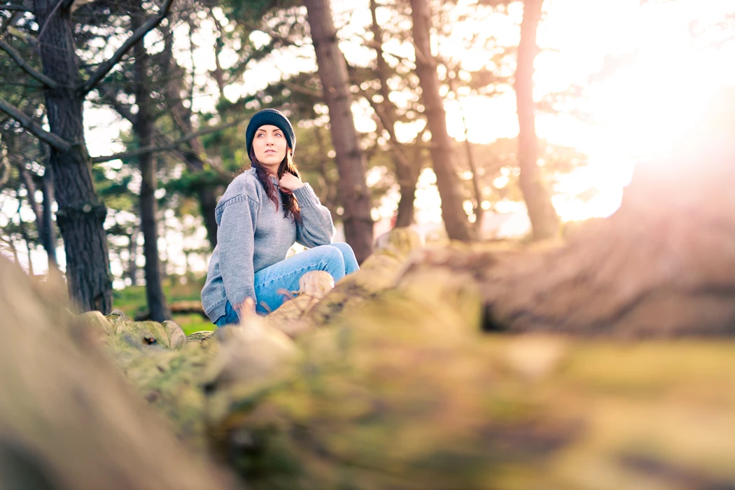 Colour photo of a man sitting in a forest