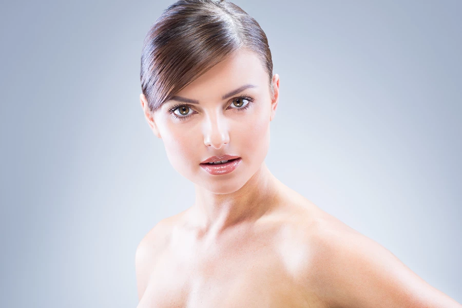 Studio beauty photo of woman against grey background