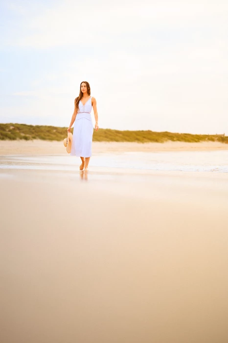 Colour photo of a person walking on a beach