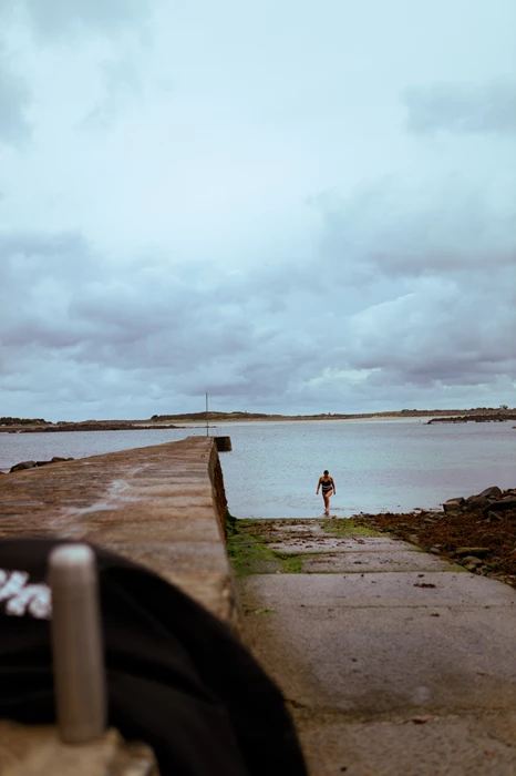 Colour photo of a person standing on a beach