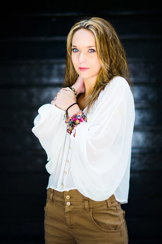 Lifestyle photo of woman in white blouse against dark background
