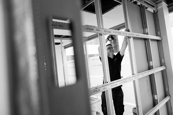 Black & white documentary style photo of man using electric screwdriver