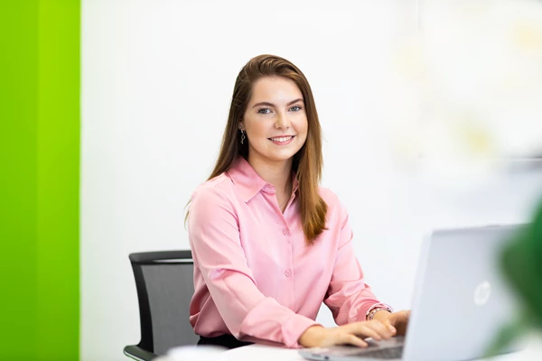 Colour photo of a woman sitting at a desk