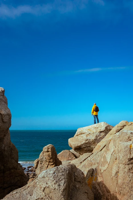 Colour photo of a person standing on a rock