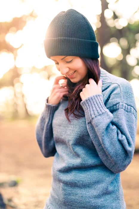 Colour photo of a person wearing a hat and smoking a cigarette